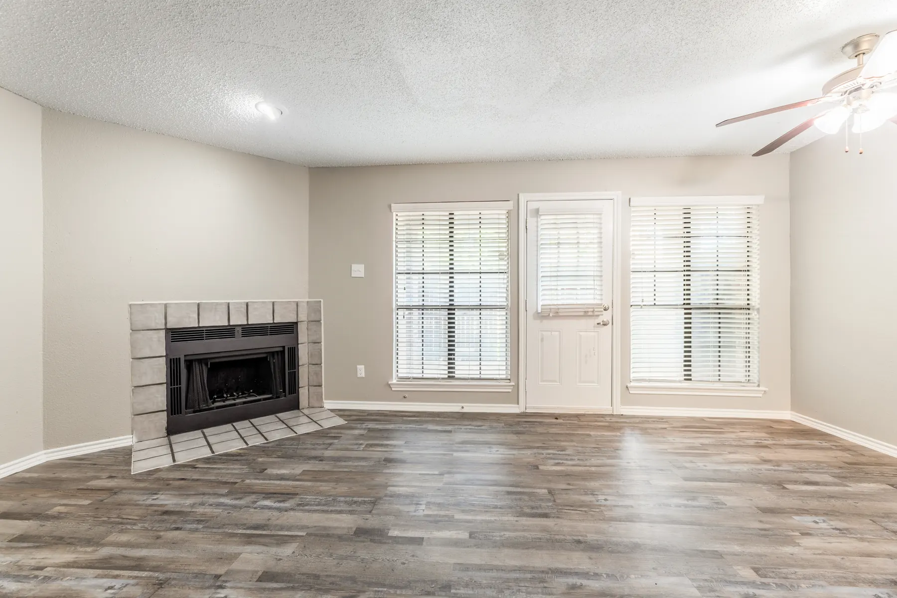 Living room with tiled fireplace, wood-style flooring and patio door