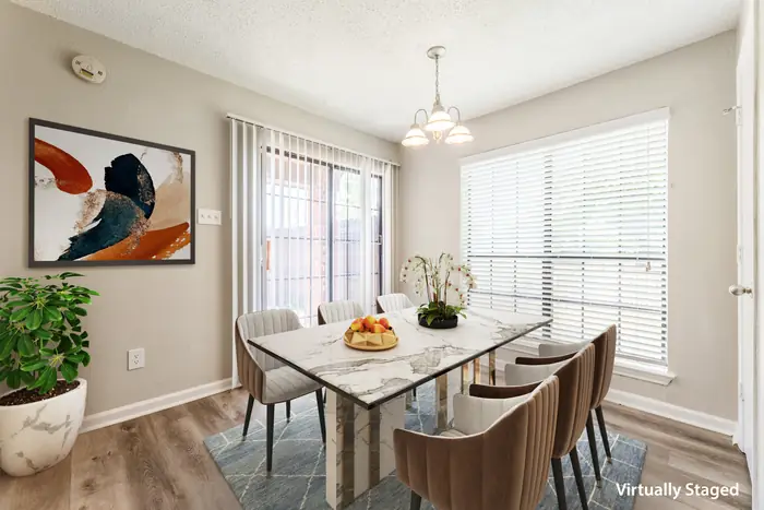 Dining area with chandelier and large windows (virtually staged)